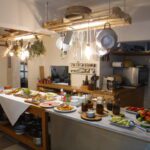 A breakfast table in Greece is fully loaded with food.