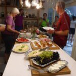 People serving themselves food from a buffet table indoors.