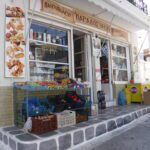 A quaint bakery storefront with fresh bread and pastries displayed outside.