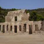 Ruins of an ancient stone building under a clear blue sky.