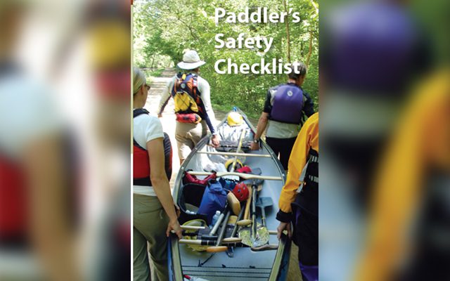Paddlers preparing safety checklist before canoeing.