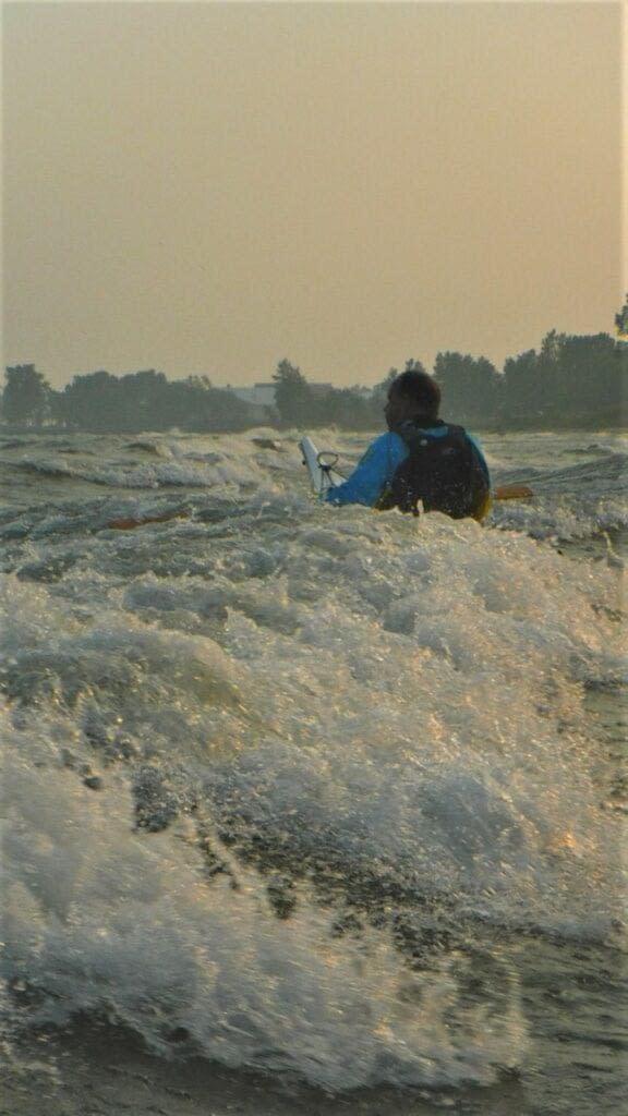 DSCF1171-576x1024 Person kayaking on turbulent water during sunset.