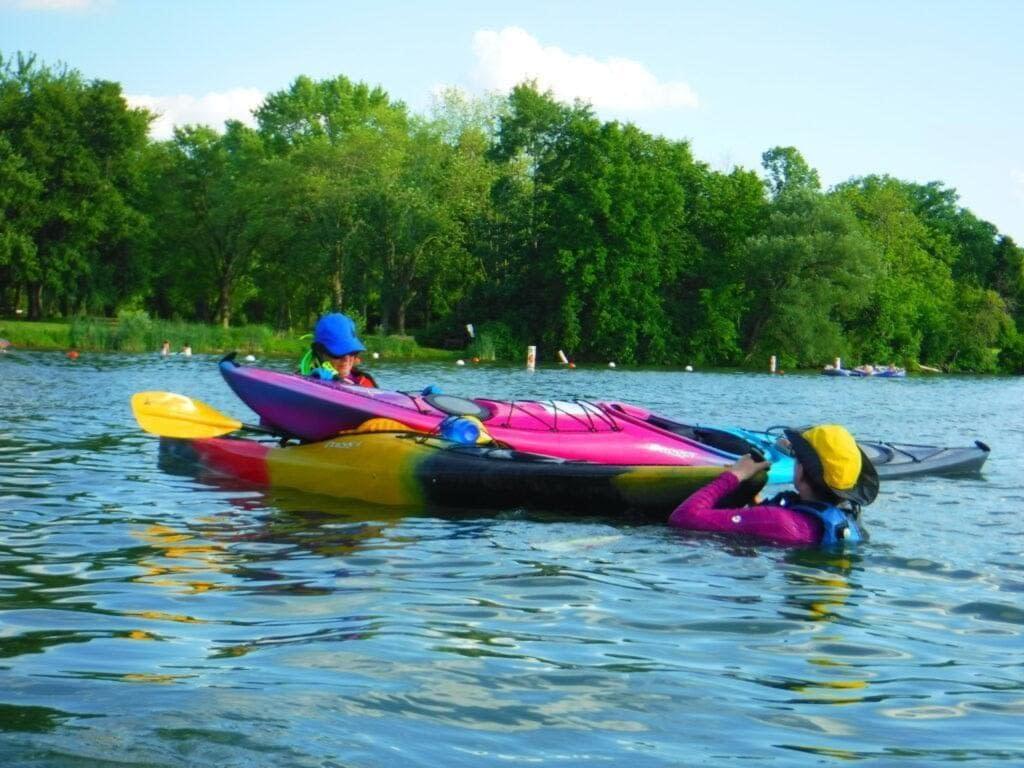 DSCF1741-1024x768 Two people kayaking on calm water surrounded by greenery.