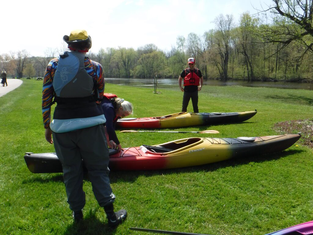 DSCF4121-1024x768 People preparing kayaks on the grass near a wooded area.