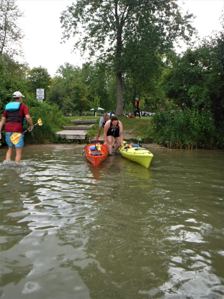 DSCF4414-768x1024 Two people kayaking in a calm river surrounded by greenery.