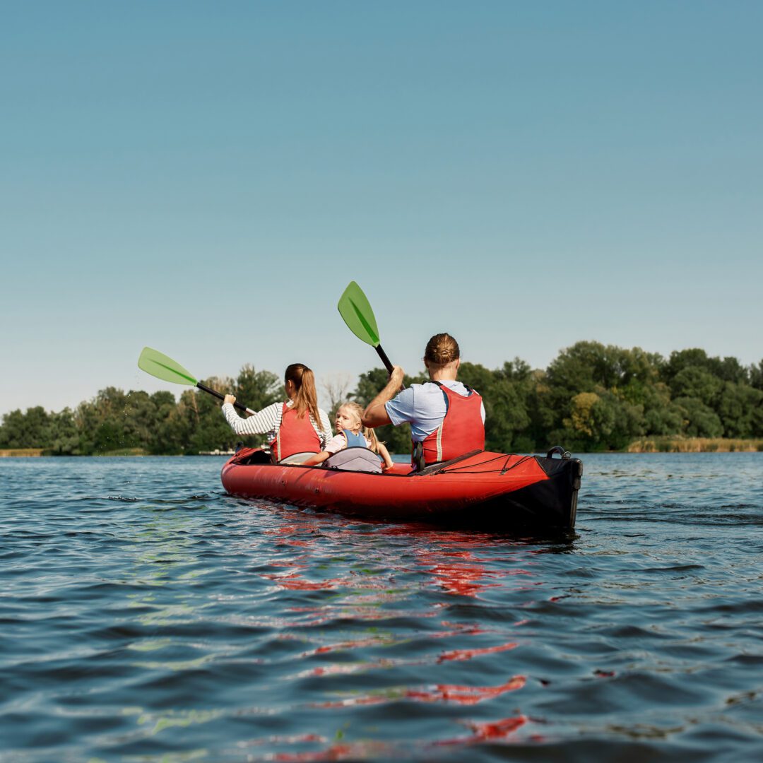 Family kayaking on a calm lake.