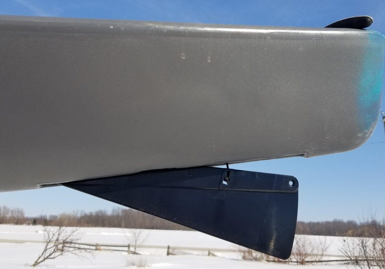 A skeg deployed, as it hangs down on the underside of a kayak