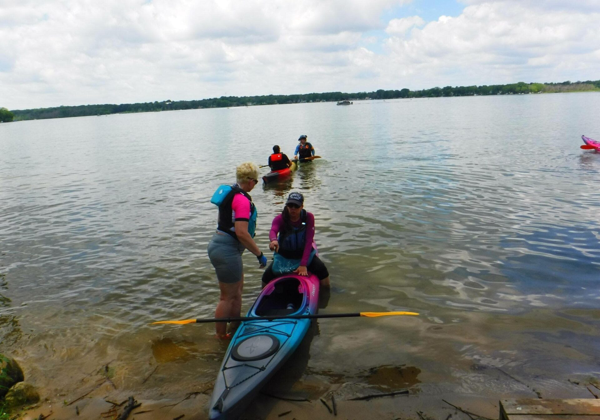 learn how to kayak a student gets instruction how to properly get inside the kayak