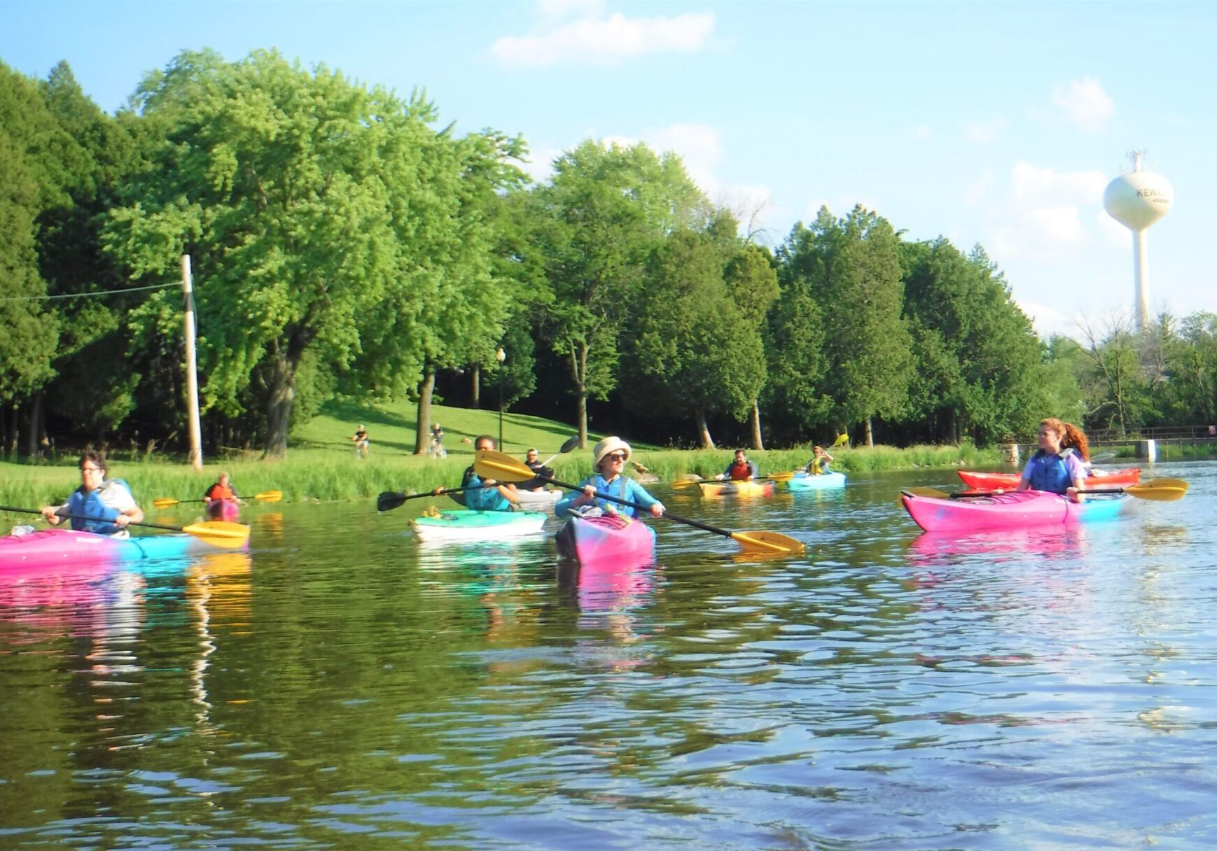 A group of nine paddle on the river in Kewauskum. Smiles are on their faces.